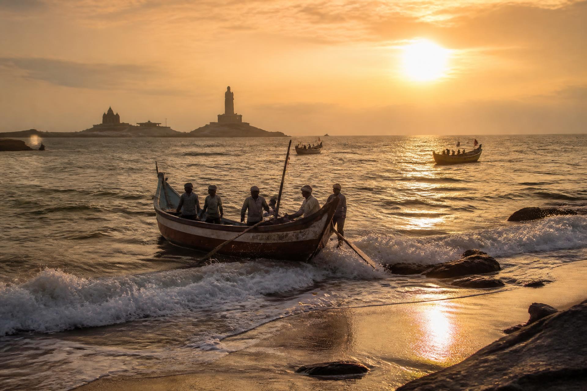 Sunrise over Kanyakumari with fishing boats leaving the shore